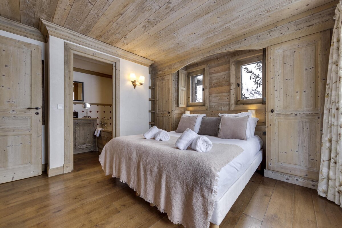 A bedroom with wooden walls and a large bed