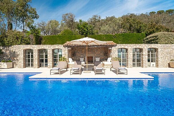 A large swimming pool with chairs and umbrellas around it