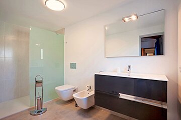 A bathroom with a toilet a bidet and a sink