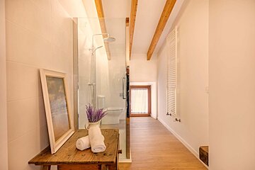 A bathroom with a walk in shower and a picture on the wall