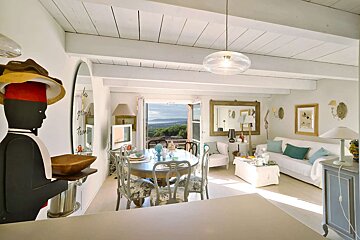 A living room with a table and chairs and a mirror