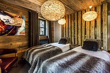 A bedroom with two beds and a painting on the wall