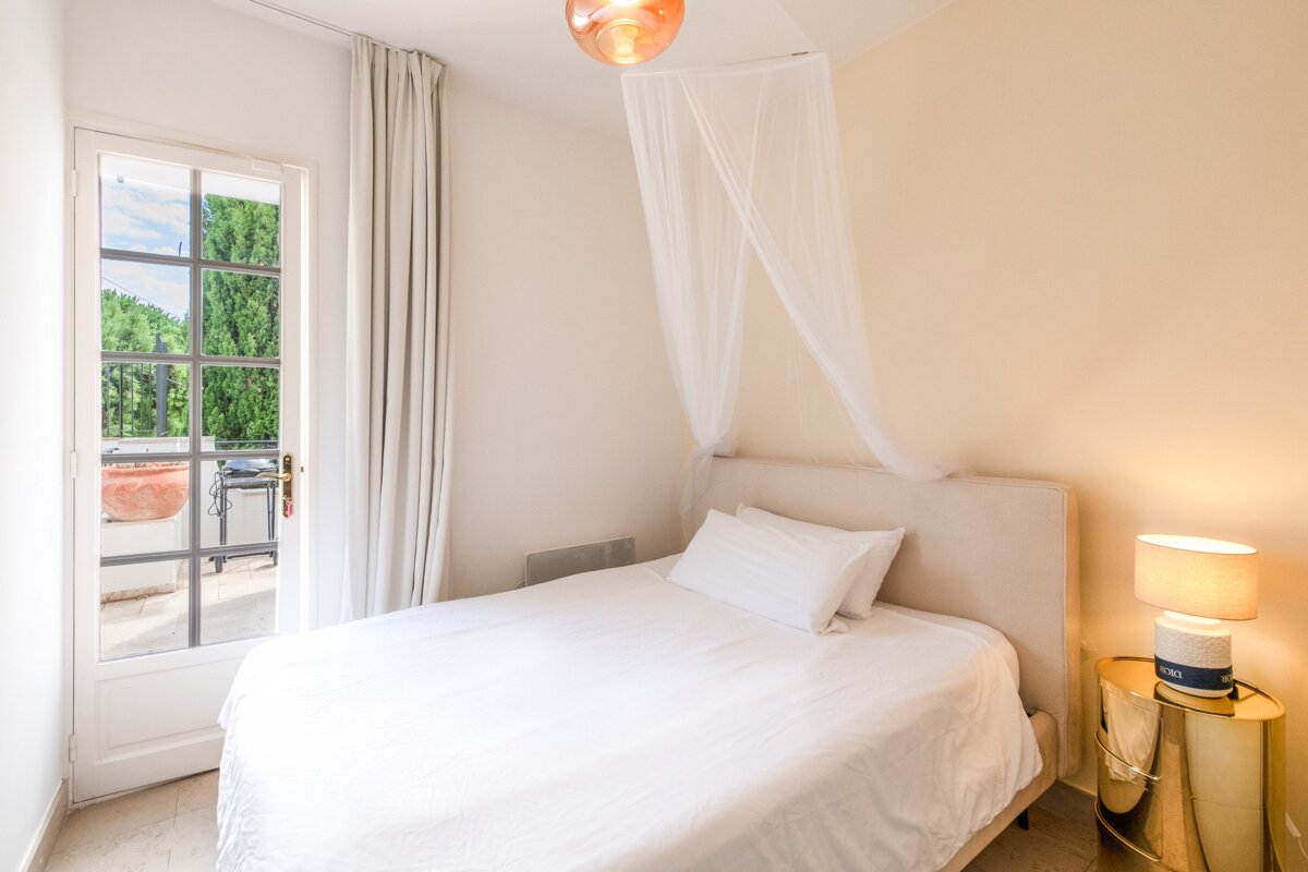 A bedroom with a canopy bed and a lamp