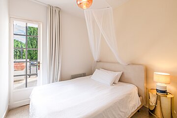 A bedroom with a canopy bed and a lamp