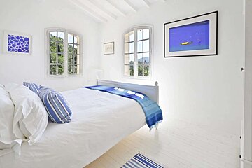A bedroom with a bed and a picture on the wall