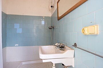 A bathroom with blue tiles and a white sink