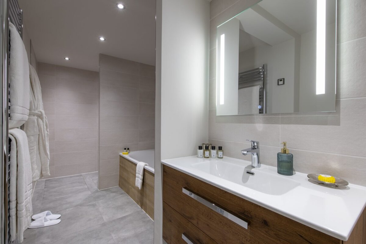 A bathroom with a sink a mirror and a bathtub