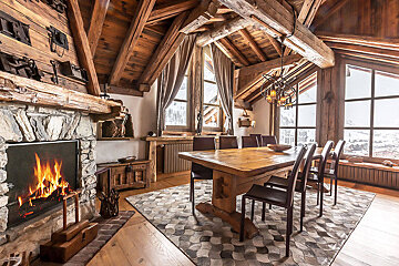A dining room with a table and chairs and a fireplace