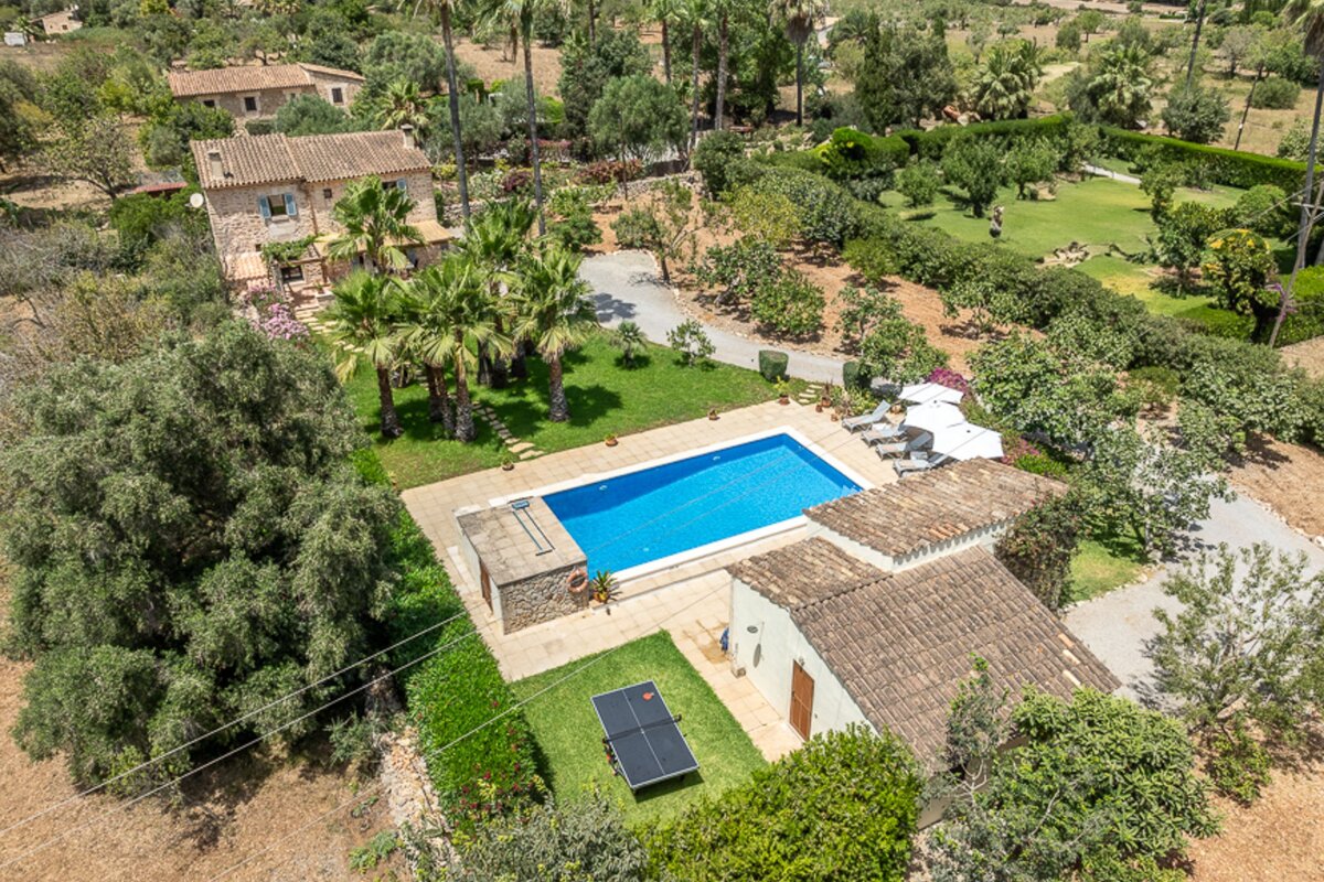 An aerial view of a house with a large pool