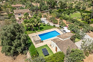 An aerial view of a house with a large pool