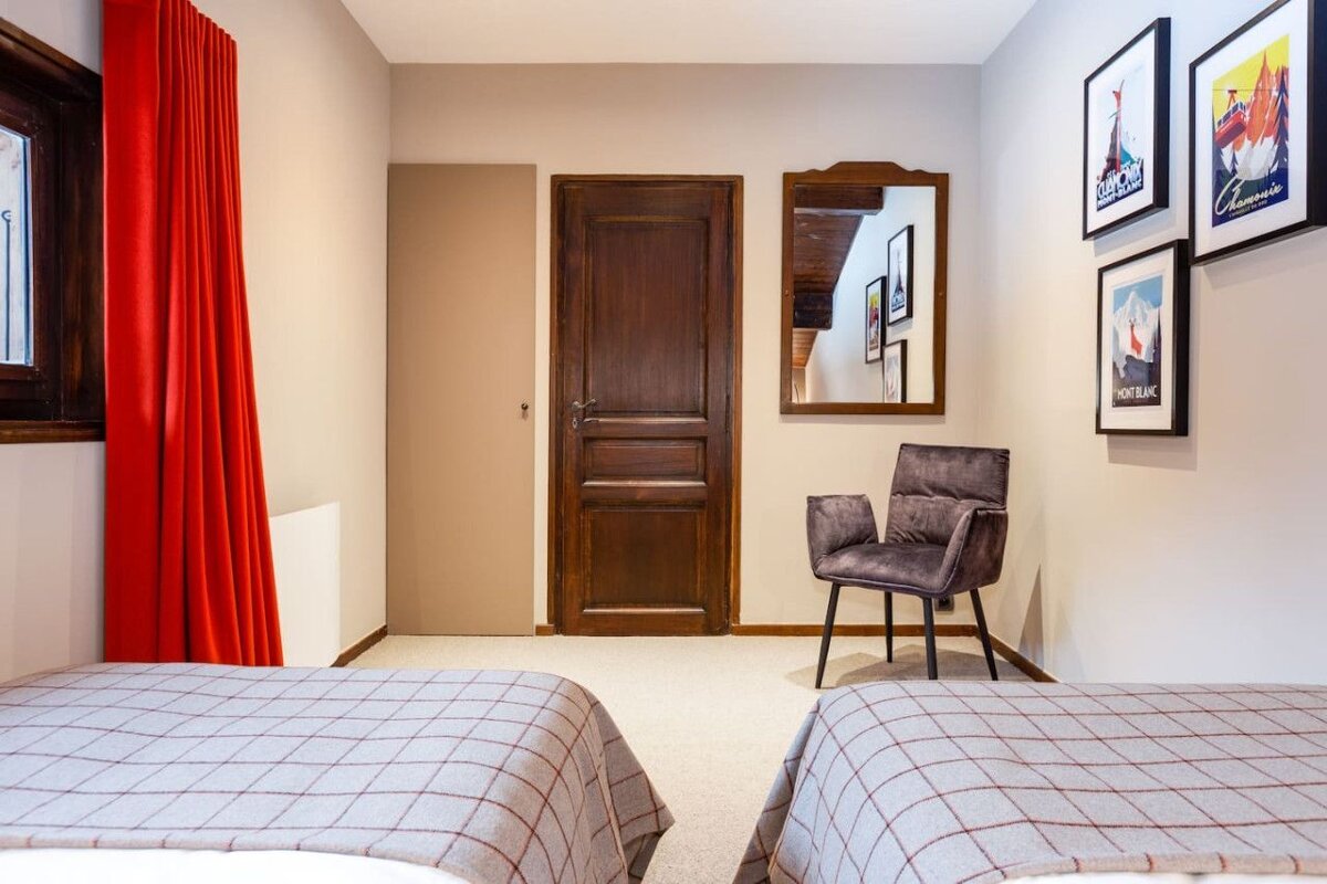 A bedroom with two beds and a chair with a picture on the wall that says mont blanc