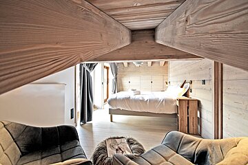 A bedroom with a bed and a chair in it