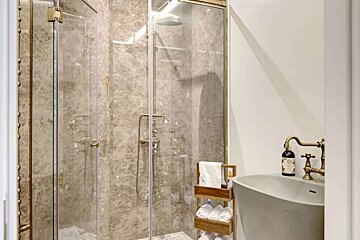 A bathroom with a sink and a shower stall