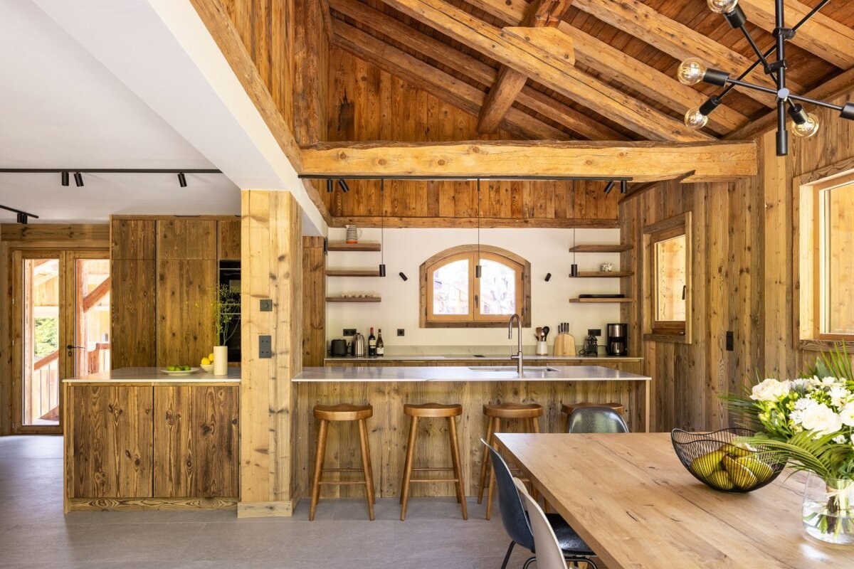 A kitchen with wooden cabinets and a stainless steel sink