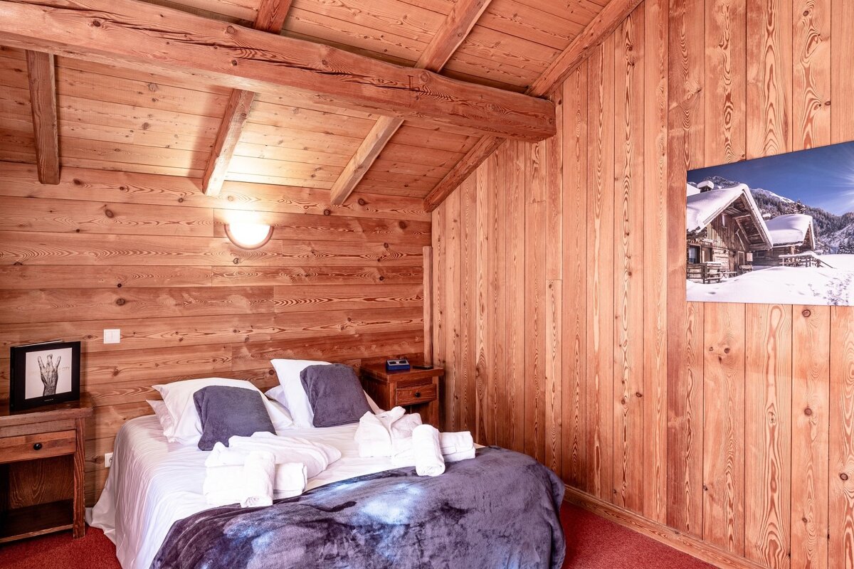 A bedroom with a bed and a picture on the wall