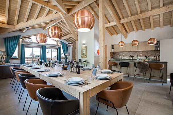 A long wooden table with plates and glasses on it
