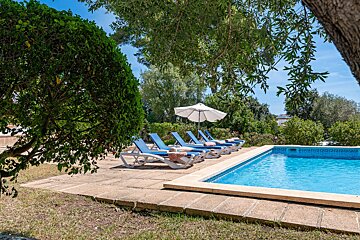 A swimming pool with chairs and umbrellas around it