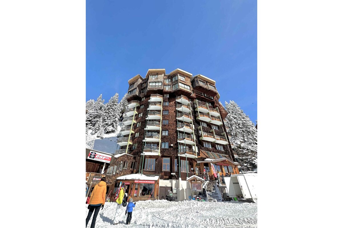 A very tall building with many balconies and a sign that says ' a ' on it