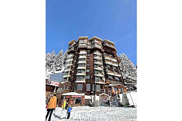 A very tall building with many balconies and a sign that says ' a ' on it