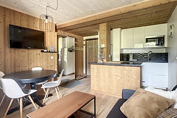 A living room with a table and chairs and a tv