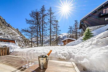 A bucket of champagne sits on a table in the snow