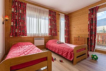 A bedroom with two beds and a soccer ball on the floor