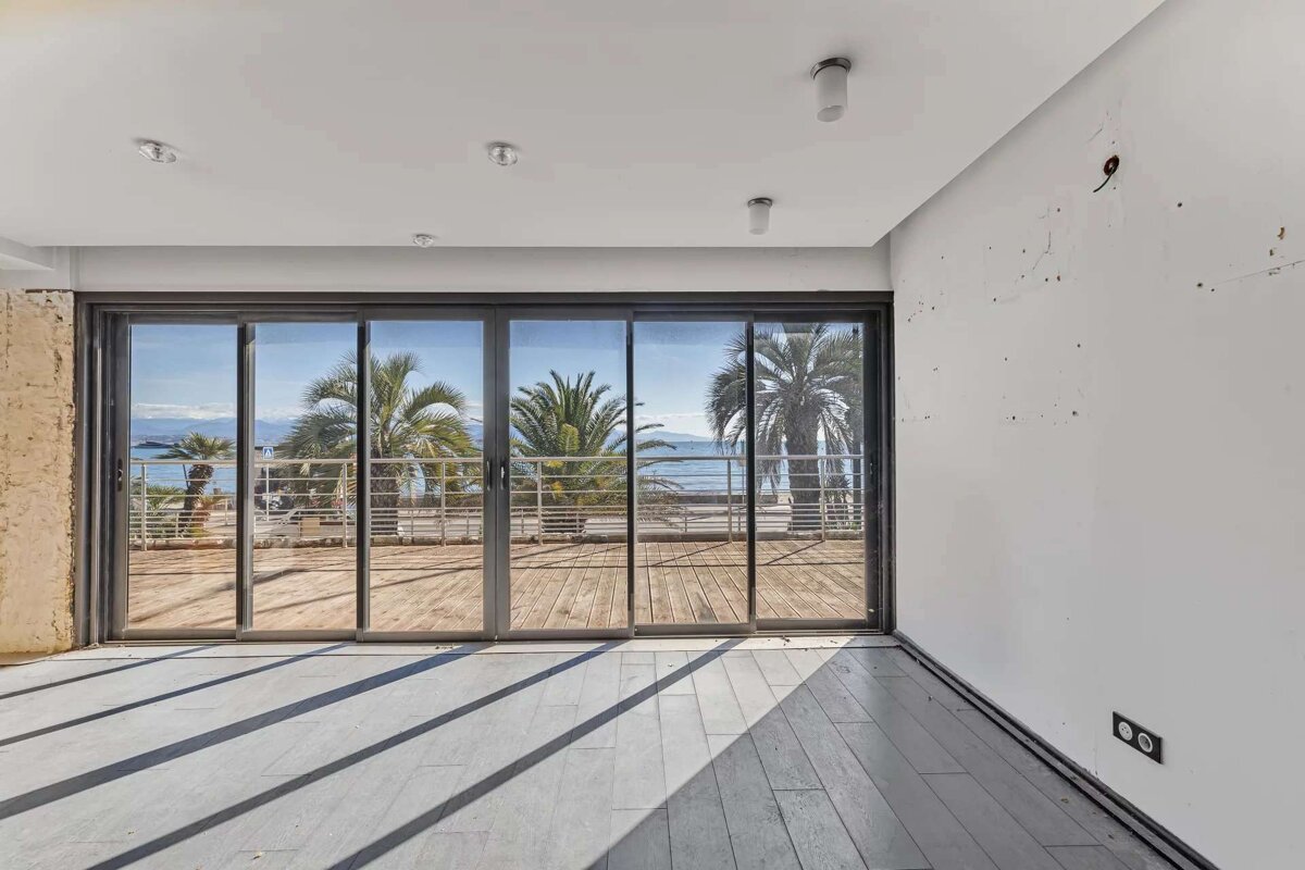 An empty room with sliding glass doors leading to a balcony
