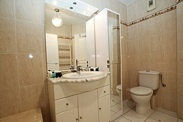 A bathroom with a sink toilet and mirror