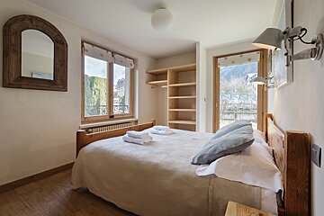 A bedroom with a large bed and a mirror