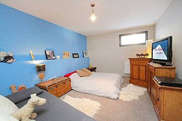 A bedroom with a large bed and a flat screen tv