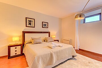 A bedroom with a king size bed and two lamps