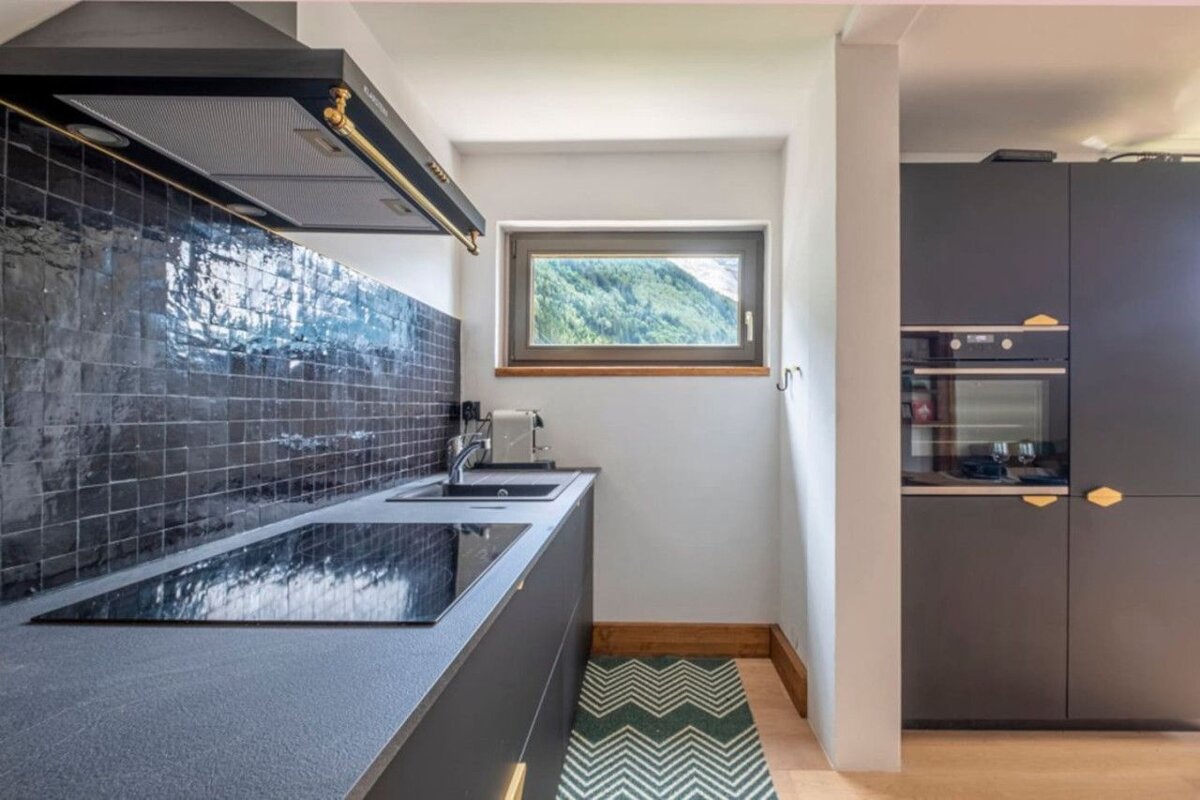 A kitchen with black cabinets and a stove top oven