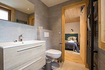 A bathroom with a toilet a sink and a mirror