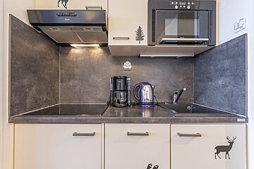 A small kitchen with a coffee maker and a kettle