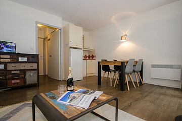 A bottle of champagne sits on a table in a living room