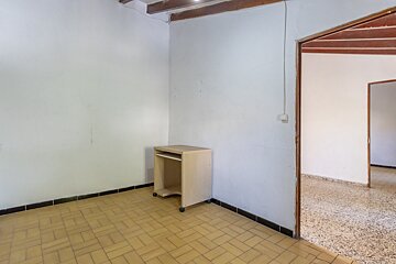 An empty room with a small desk in the corner