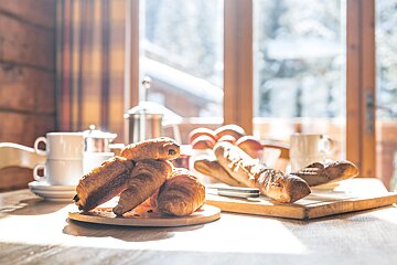 A bunch of croissants on a cutting board on a table