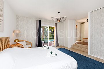 A bedroom with a large bed and a sliding glass door that says home sud