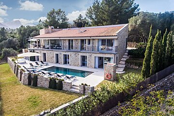 An aerial view of a large house with a swimming pool
