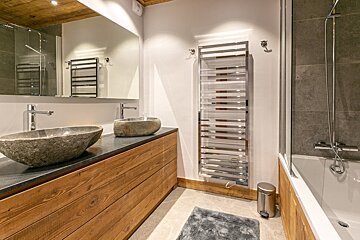 A hallway with wooden shelves and a wooden bench