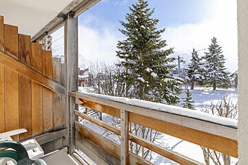 A balcony with a view of snow covered trees