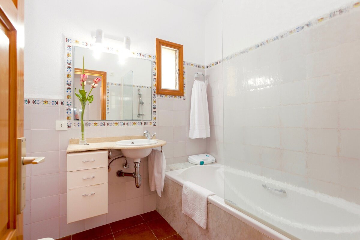 A bathroom with a sink a tub and a mirror