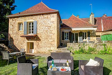 A stone house with a patio area in front of it