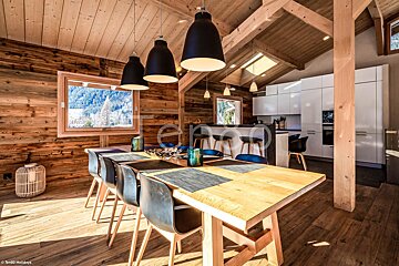 A dining room with a wooden table and black chairs