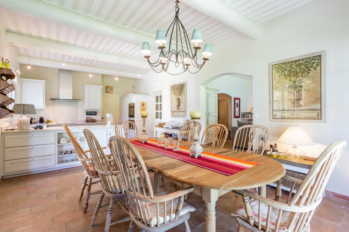 A dining room with a table and chairs and a chandelier