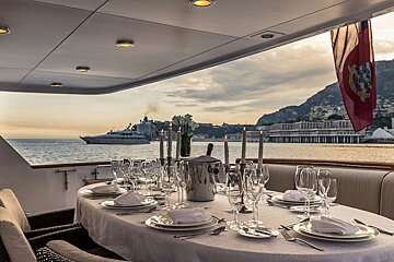 A table set for a dinner with a boat in the background