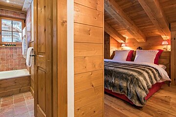 A bedroom with a bed and a bathtub in it
