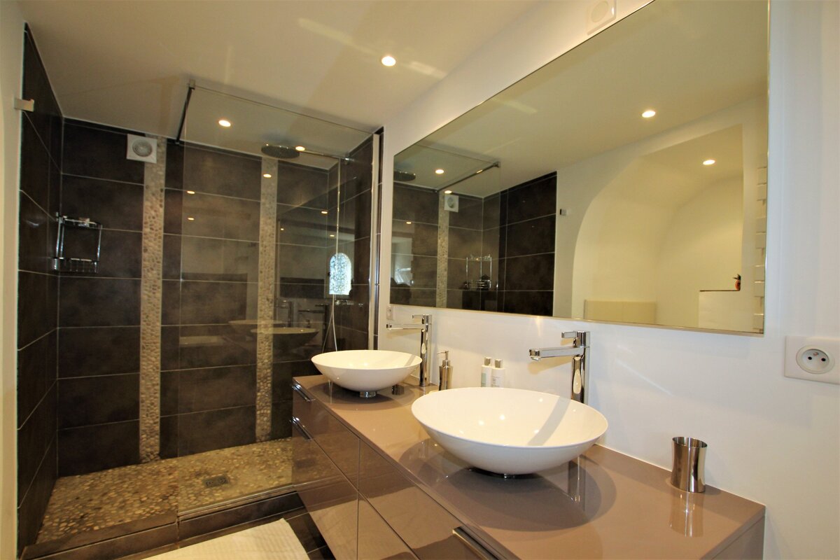 A bathroom with two sinks and a walk in shower