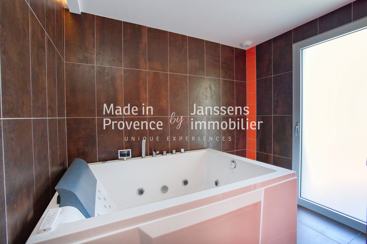 A bathroom with a jacuzzi tub and the words made in provence by immobilier
