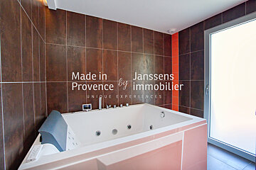 A bathroom with a jacuzzi tub and the words made in provence by immobilier